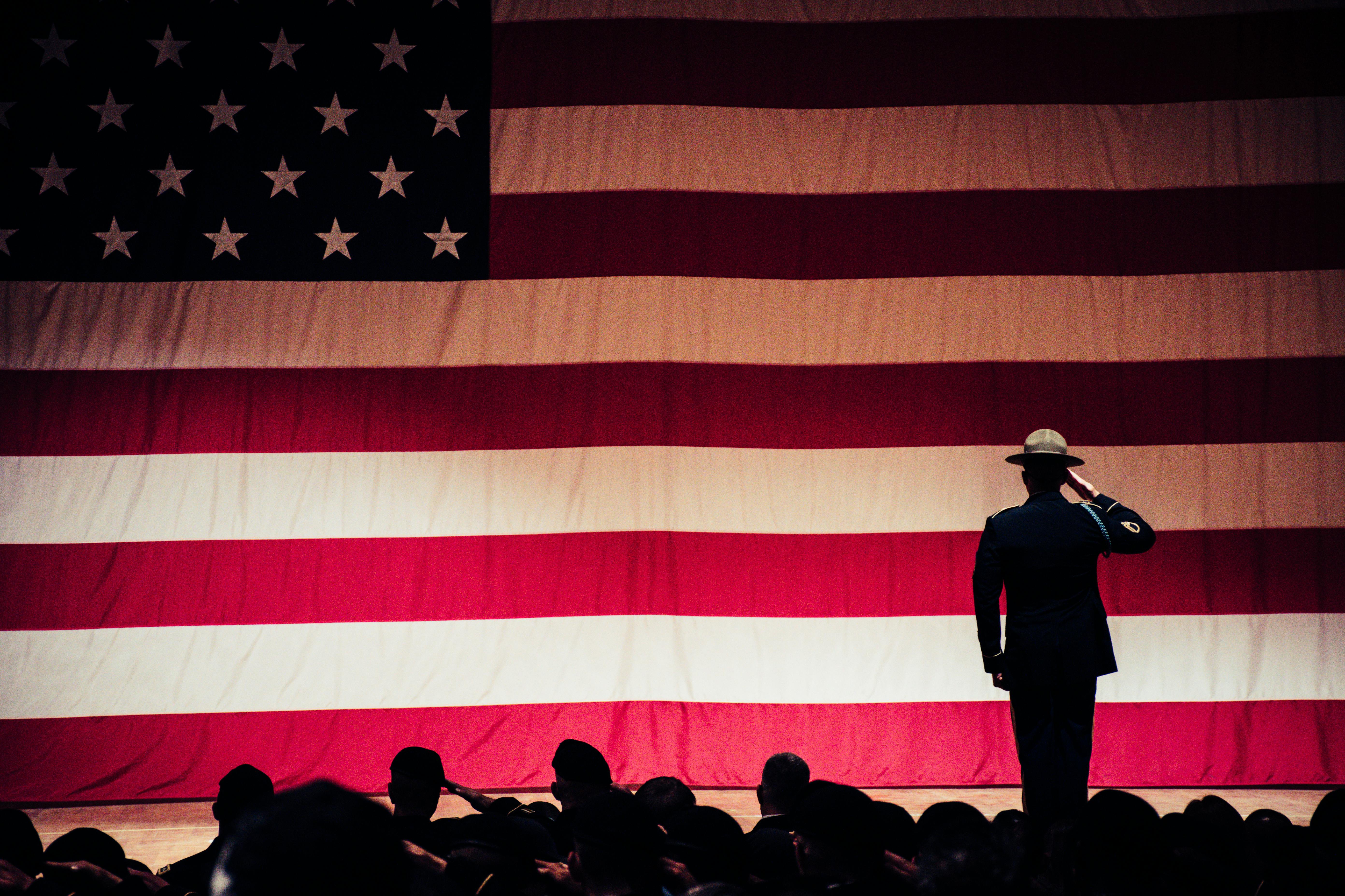 soliders saluting to the U.S. flag