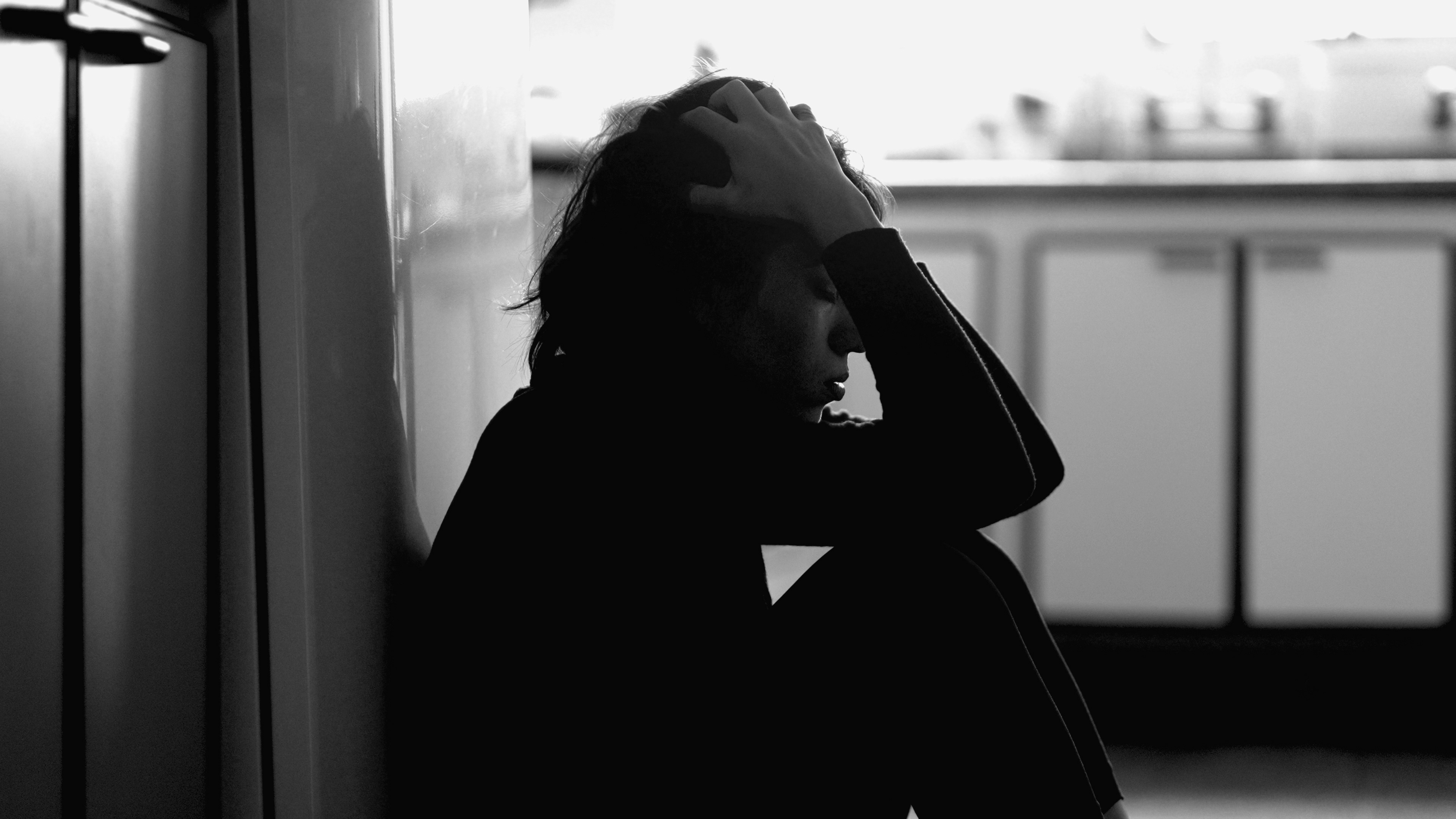 woman sitting  holding her head and overwhelmed